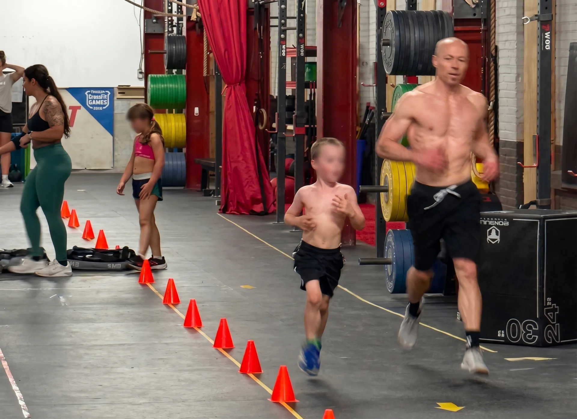 Parent et enfant s'entraînant côte à côte sous la supervision d'un coach