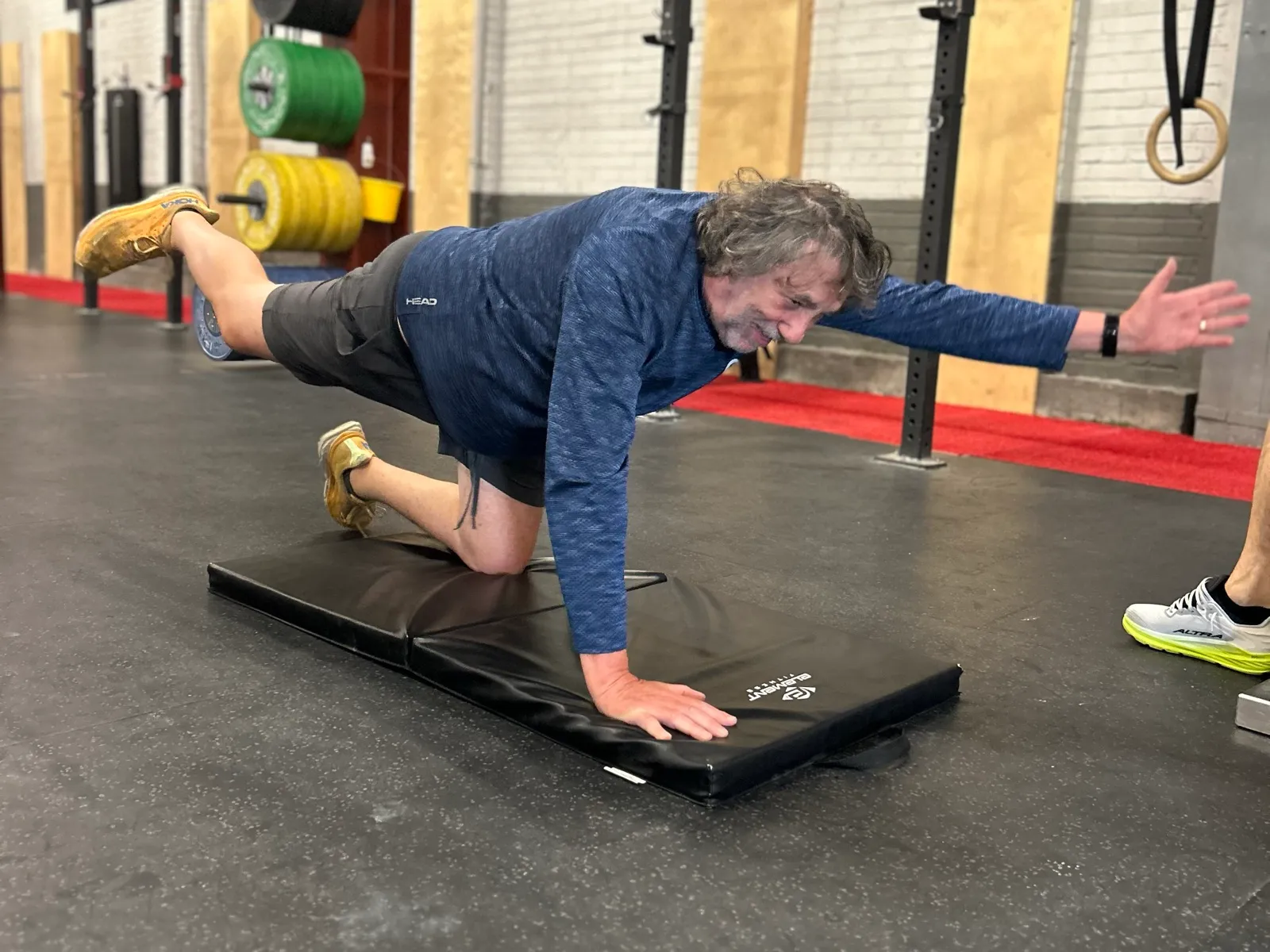 Participant de PRO1 Vitalité en équilibre sur un tapis, encadré par un coach